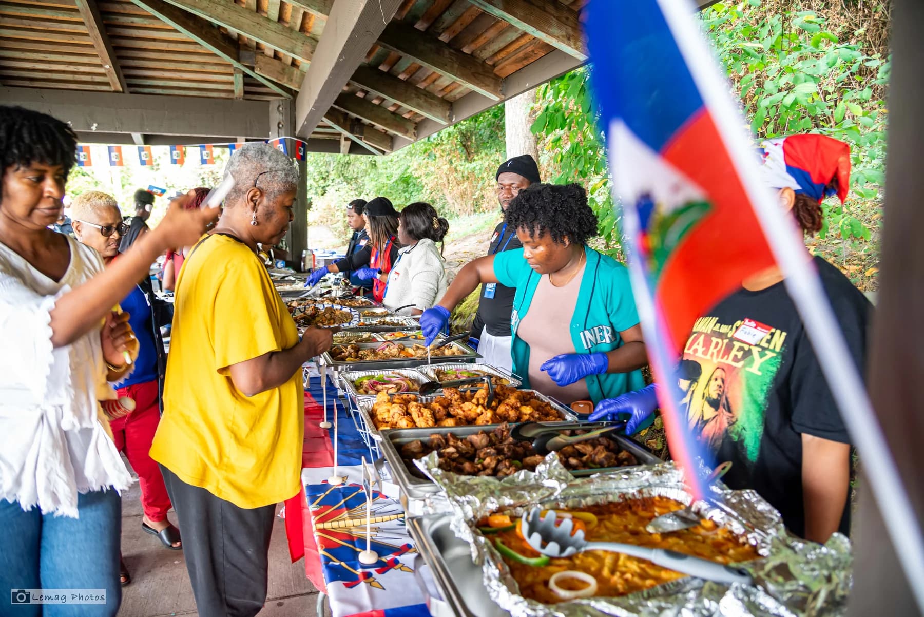Community resource fair with volunteers and Haitian food